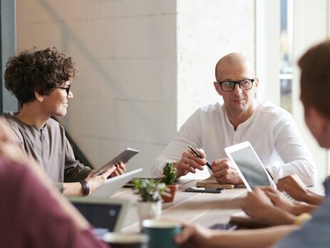 Man sitting in front of young employees 