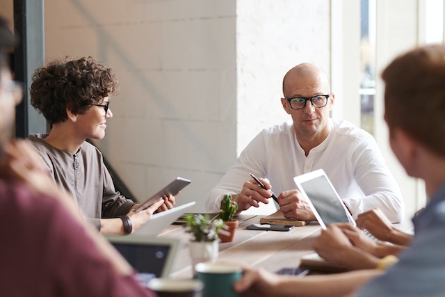 Man sitting in front of young employees 