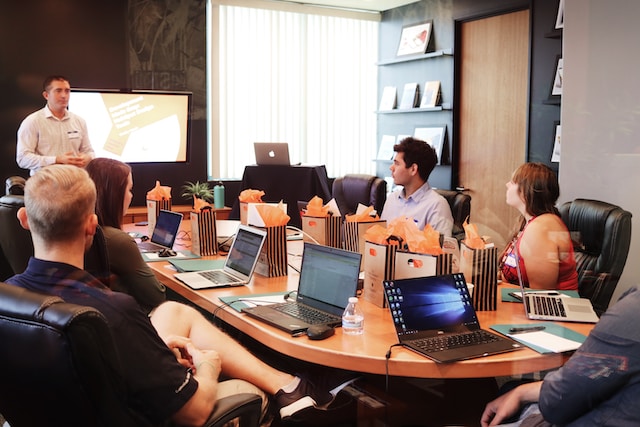 A person giving a presentation to managers in an office.