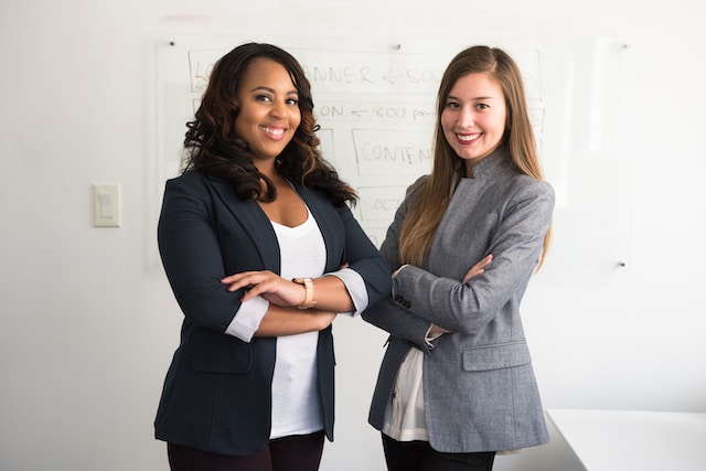Two co-workers standing confidently in an office.