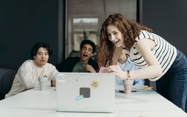 People laughing and looking at a laptop