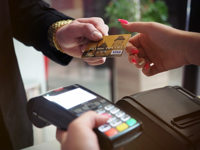 A customer handing out atm card to complete a transaction