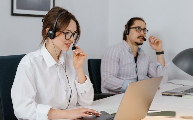 A man and woman sitting with computers in front of them