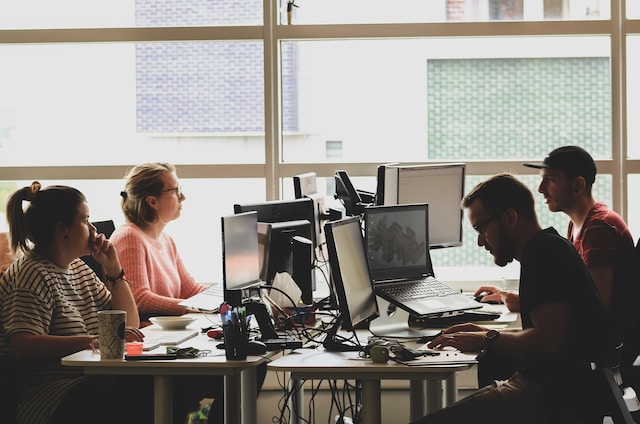 A group of co-workers in their office on their computers.