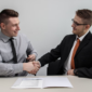 two men shaking hands after business deal 