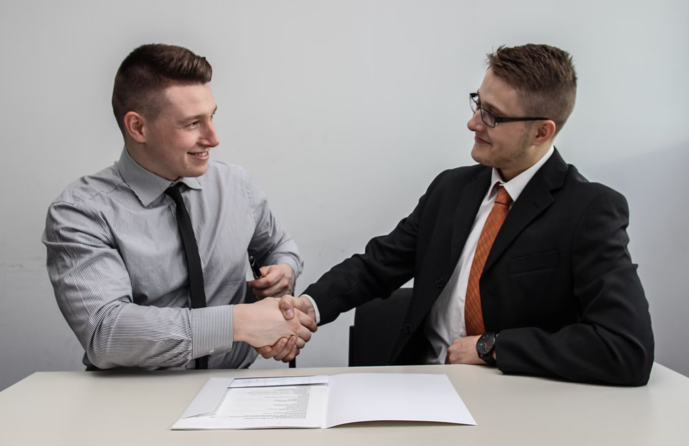 two men shaking hands after business deal 