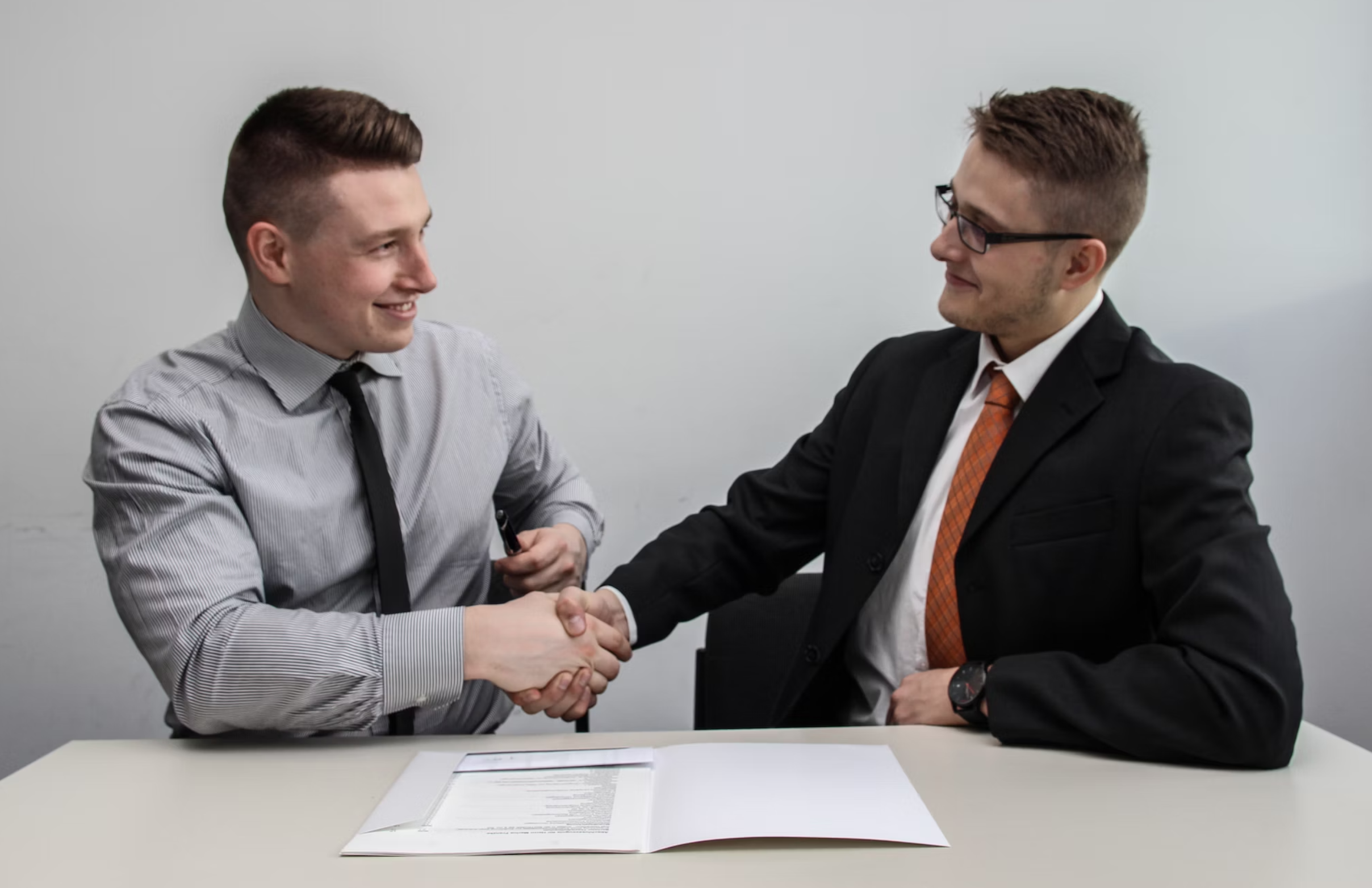 two men shaking hands after business deal 