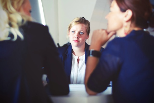 A woman facing two interviewers