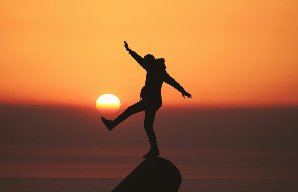 A man jumping around in the sunset on vacation.