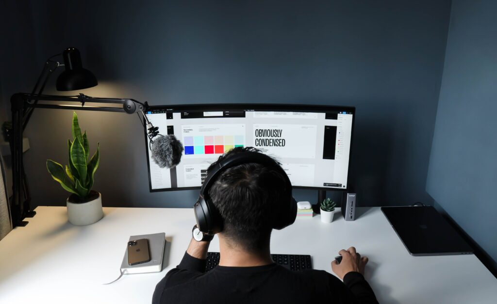 A Man sits in front of a desktop working on a design.