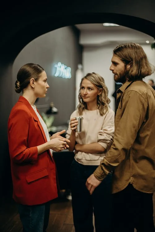 Two women and a man talking
