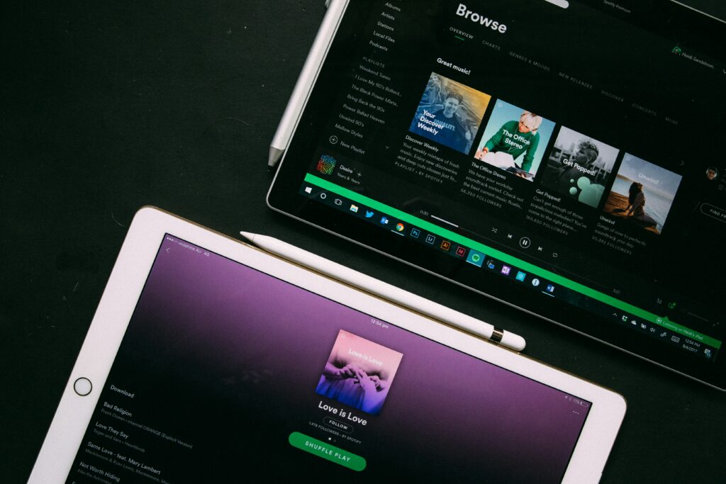 Spotify interface on laptop and iPad.
