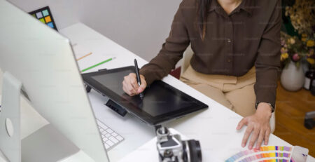 A woman working as a designer on an iPad.