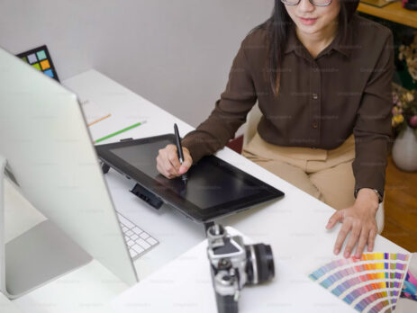 A woman working as a designer on an iPad.