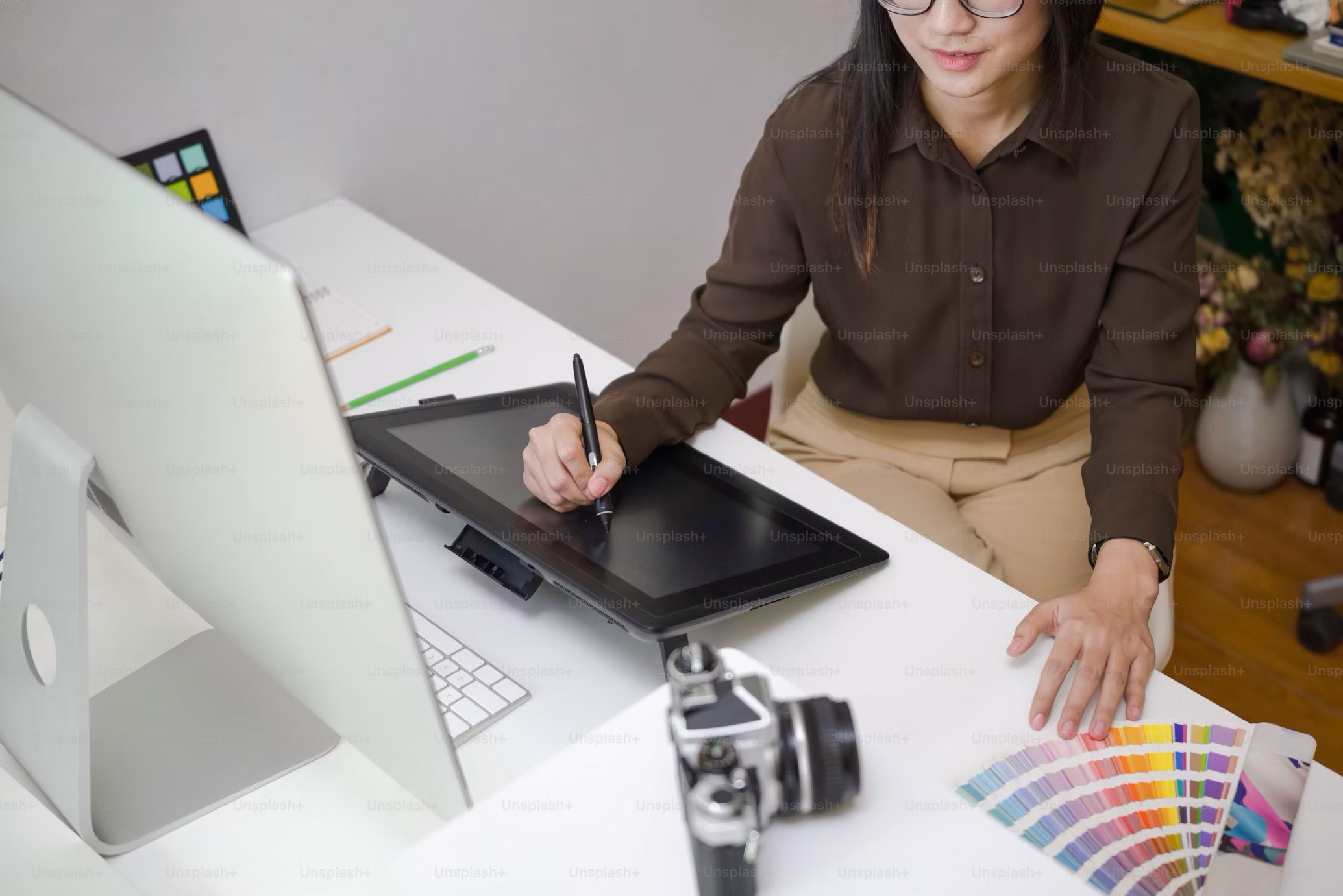 A woman working as a designer on an iPad.