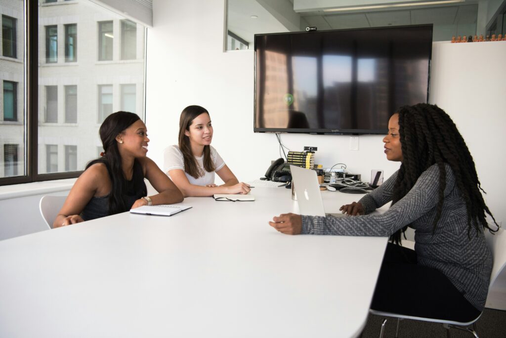 Three women sit on a table