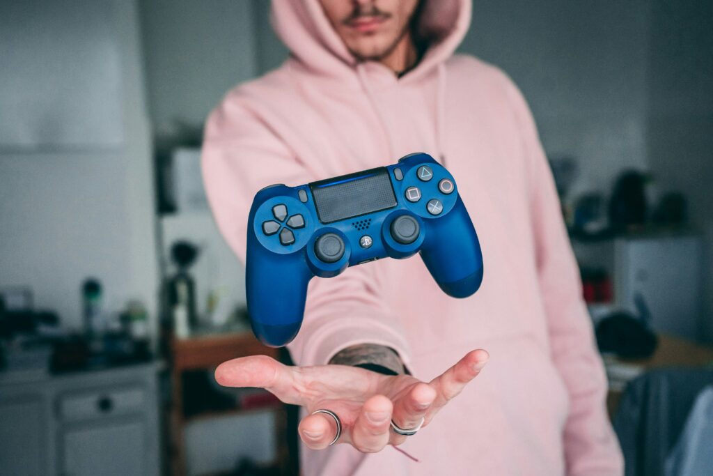 Person holding a blue sony ps4 dualshock
