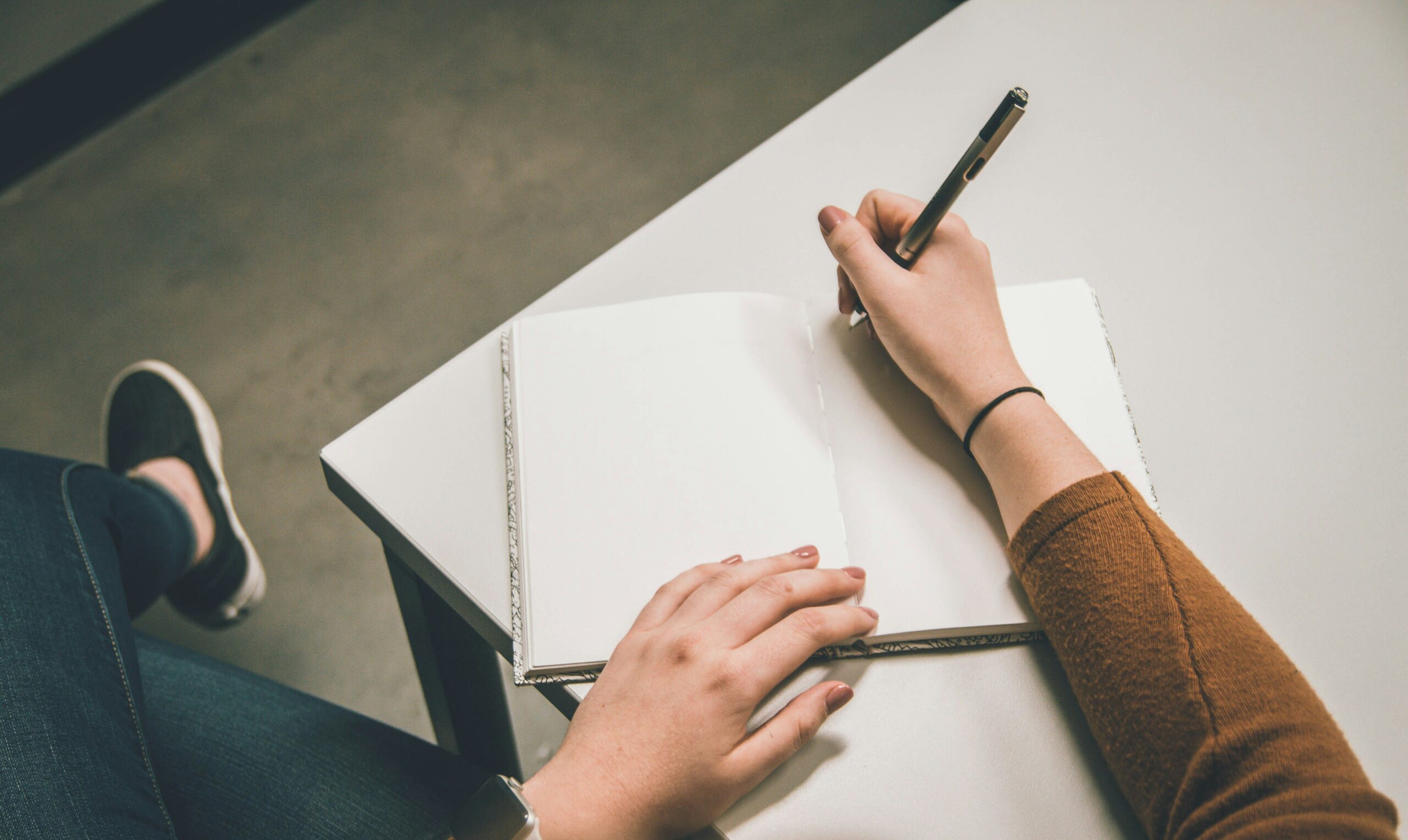 Person writing in a white paper