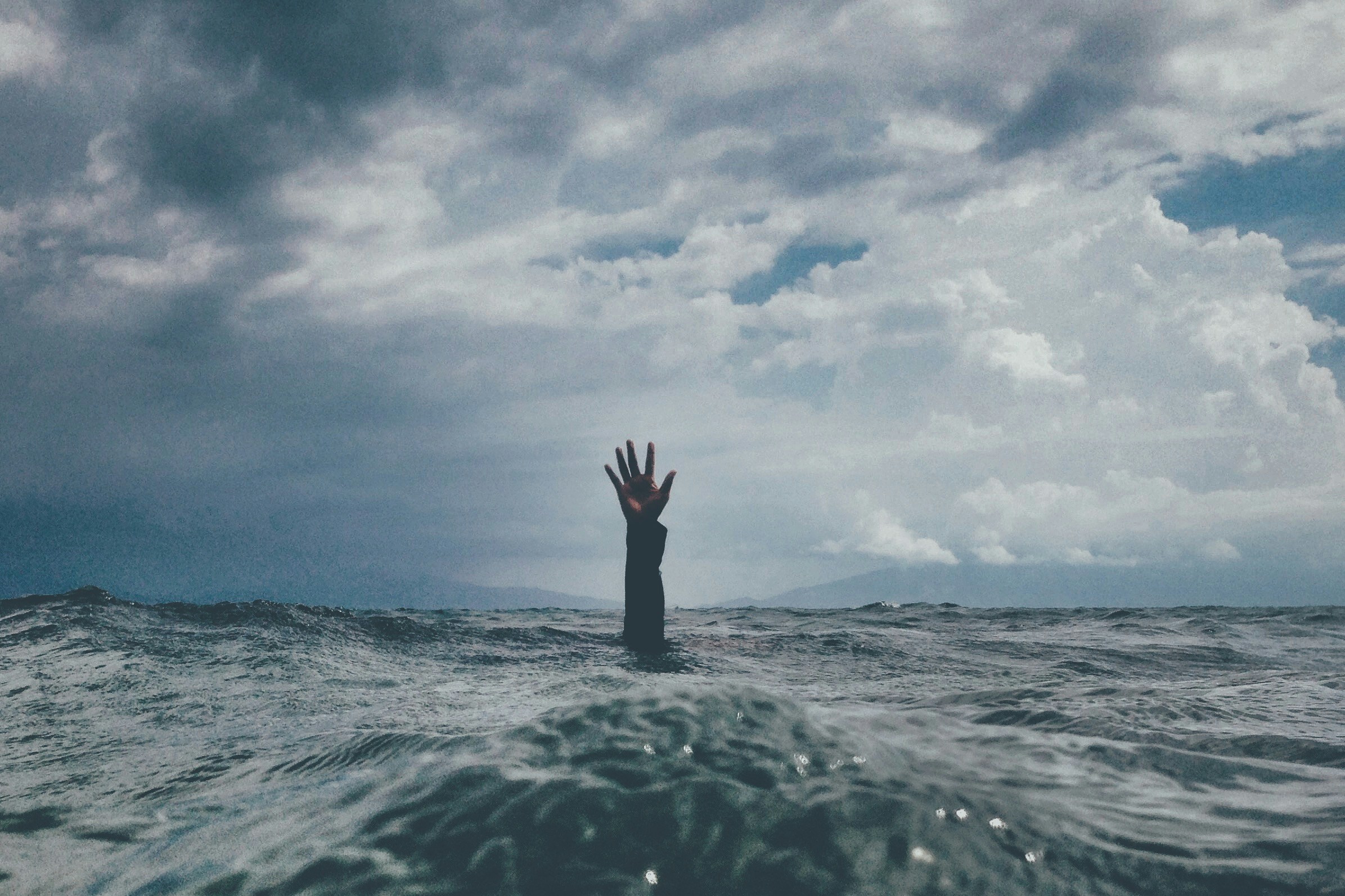 Person with hand extended over water