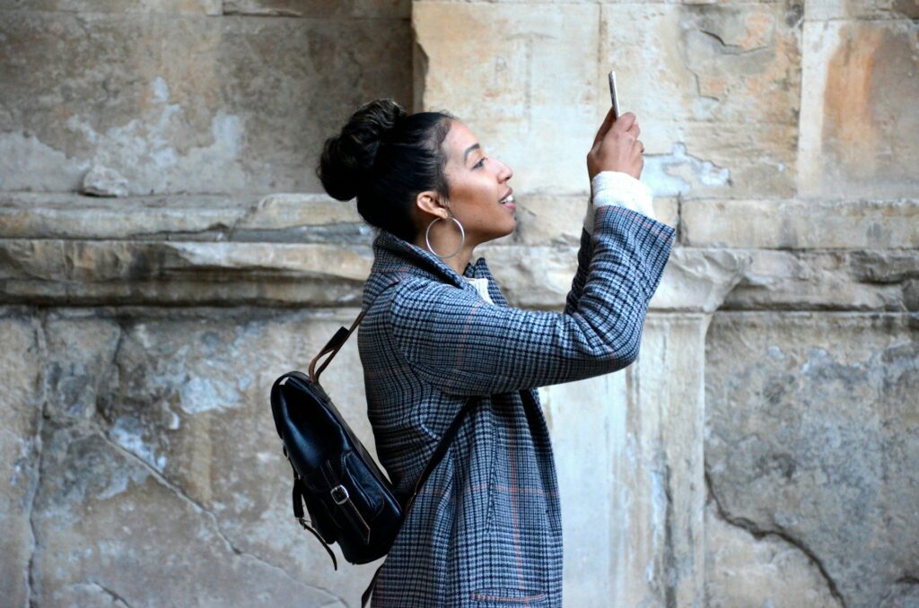 Woman looking and taking a picture with her phone