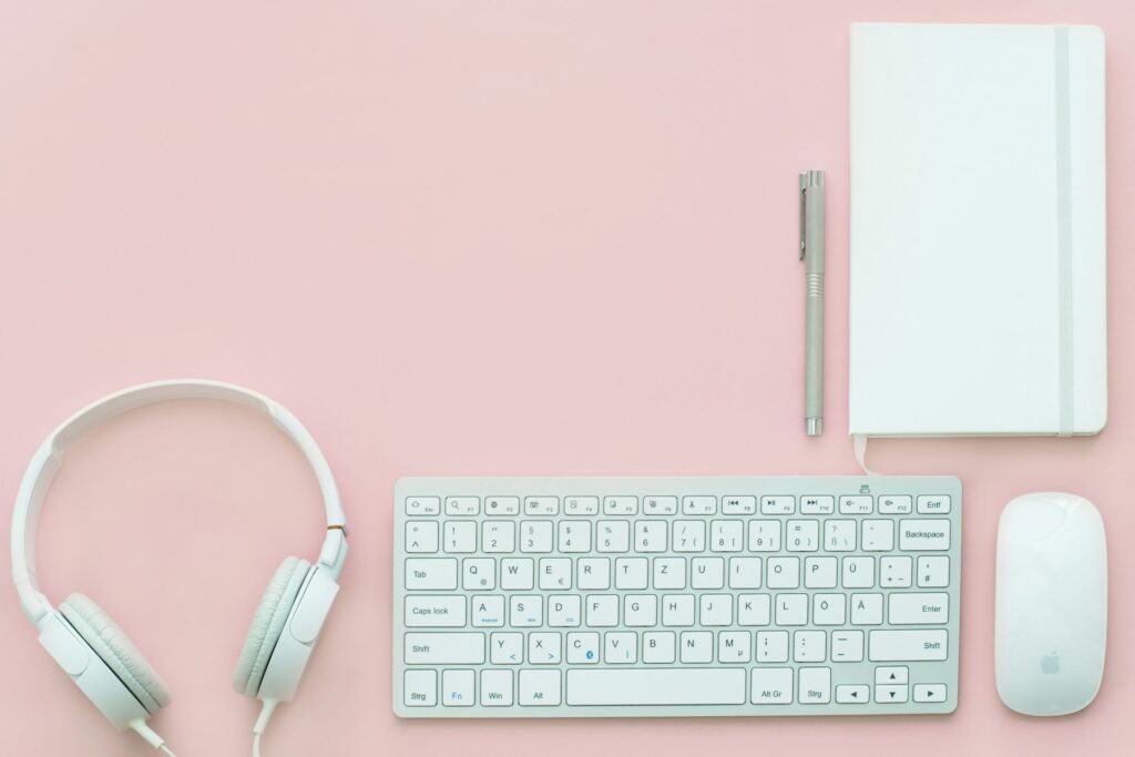 a keypad, a headphone and a mouse in a pink table